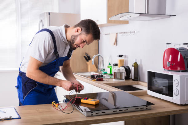 Technician testing the electrical components of a residential cooktop