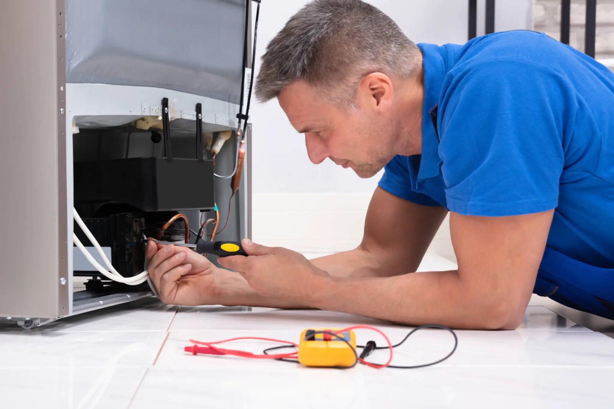 Technician testing components inside a residential ice-making appliance