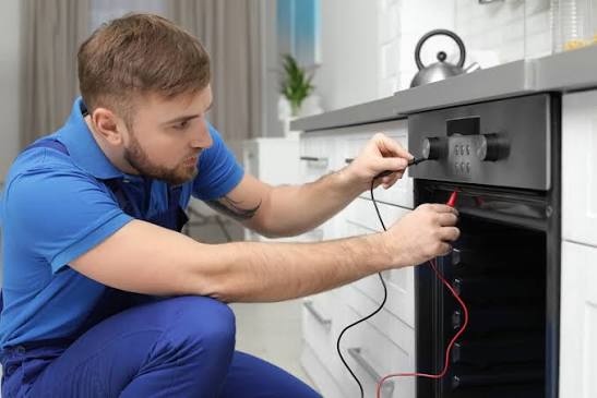 Technician testing the controls of a built-in residential oven
