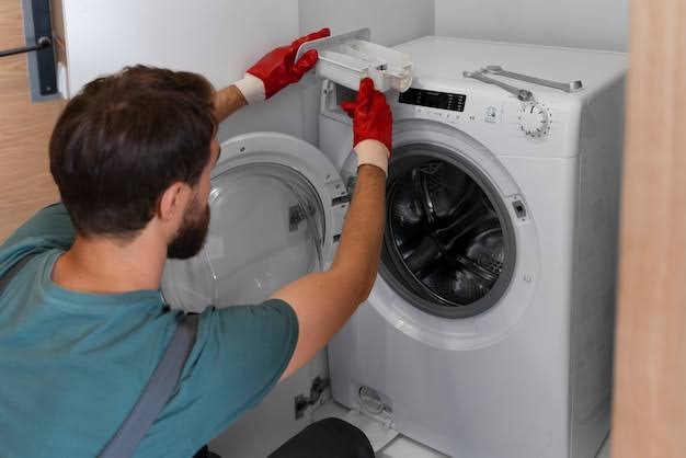 Technician opening the top panel of a front-loading washing machine